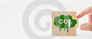 Hand completed the wooden cubes with CO2 emission reduction icon for  CO2 emission ,green industries business . Net zero emissions