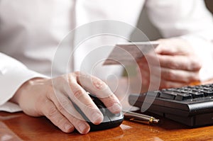 Hand on computer mouse next to the keyboard