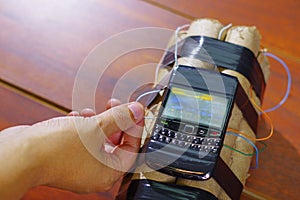 Hand connecting the cable of the explosives to the cellphone