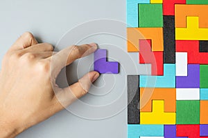 Hand connecting geometric shape block with colorful wood puzzle pieces. logical thinking, business logic, Conundrum, decision,