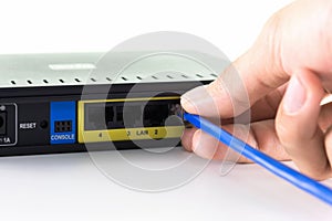 Hand connecting a yellow network cable on a network port