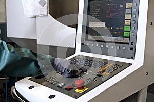 Hand on the control panel of a cnc programmable machine