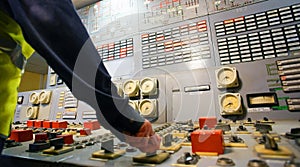 Hand on the control panel of a power plant