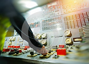 Hand on the control panel of a power plant