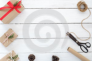 Hand crafted Christmas present gifts box and tools on white wooden background.