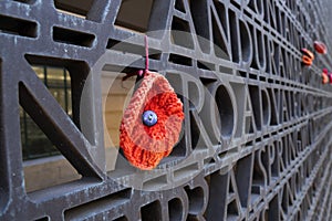 Hand crafted red poppy on a commemorative wall.