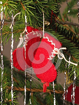 Hand crafted traditional Christmas tree decoration red boots hanging on a tree branch