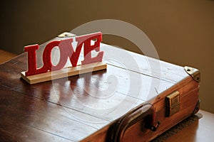 Hand crafted wood endearment that reads 'Love' set on man's briefcase