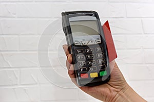 Hand with credit card and banking terminal