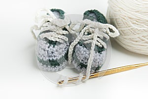 Hand crocheted baby shoes with wool, crochet needle