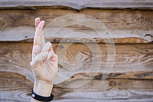 Hand with crossed fingers on wooden background . Gesturing good