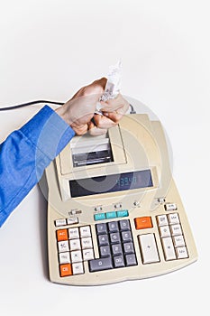 Hand crumples paper check over cash register on white background