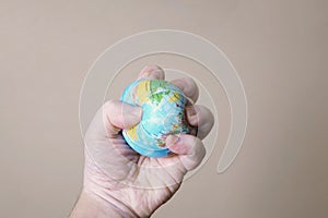 Hand crushing globe of planet earth - ecocide or destruction of environment concept