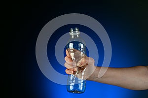 A hand crushing a recyclable plastic bottle