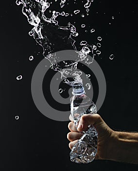 Hand crushing a water bottle