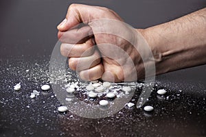 Hand crushing white pills