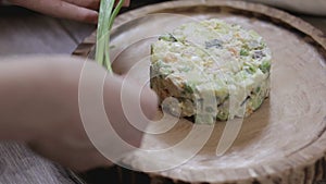 Hand decorated salad with a sprig of green onion close-up