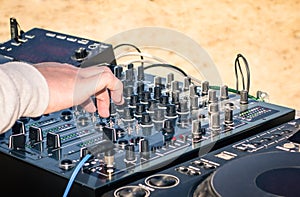 Hand of a deejay playing music on professional mixer