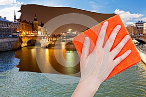 Hand deletes day view of Paris by orange cloth