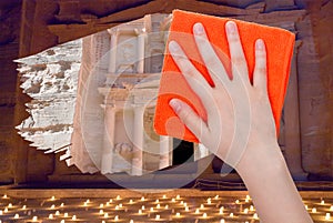 Hand deletes night view of Petra by orange rag