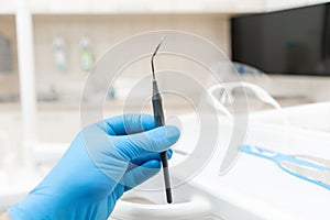The hand of the dentist in the glove holds tool mirror. Stomatological instrument in the dentist clinic. Dental work in