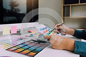 Hand designer choosing colors for doing graphic on laptop