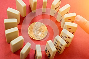 Hand destroying Circle row of Dominoes with the golden bitcoin in the center