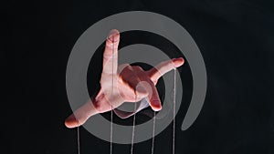 Hand of dictator in a business suit with strings on the fingers to control the puppet. Close up male hand with strings