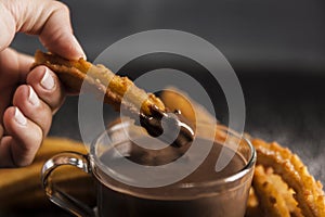 hand dipping fried churros chocolate. High quality photo