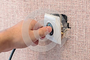 Hand disconnects or connects the plug to a broken outlet, risk of electric shock