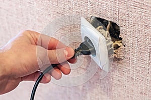 Hand disconnects or connects the plug to a broken outlet, risk of electric shock