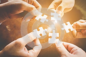 Hand of diverse people connecting jigsaw puzzle. Concept of partnership and teamwork in business