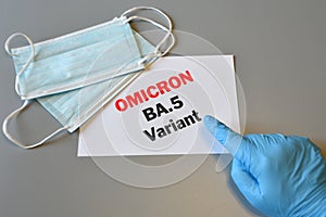 The hand of doctor in blue glove indicate text `Omicron BA.5 Variant` on white paper