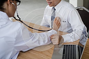 The hand of the doctor examining a patient with stethoscope in m