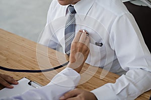 The hand of the doctor examining a patient with stethoscope in m