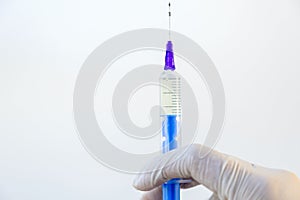 Hand of a doctor holding a syringe with an antibiotic on a white background.