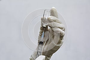 Hand of doctor holding syringe and drug, medical concept