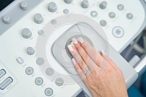 Hand of doctor lies on control panel of ultrasound device
