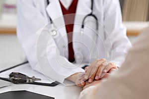 Hand of doctor reassuring her female patient