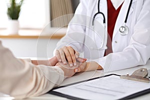 Hand of doctor reassuring her female patient