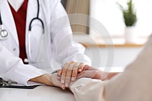 Hand of doctor reassuring her female patient