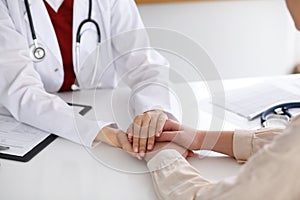 Hand of doctor reassuring her female patient