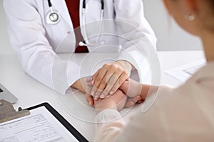 Hand of doctor reassuring her female patient