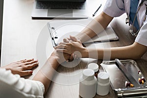 Hand of doctor reassuring her senior female patient. Medical ethics and trust concept