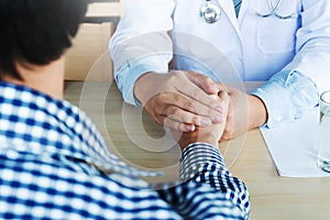 Hand of doctor reassuring his patient in hospital