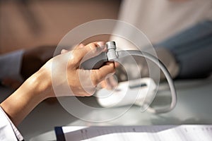 Hand of doctor using sphygmomanometer for checking blood pressure