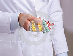 Hand of doctors holding many different pills