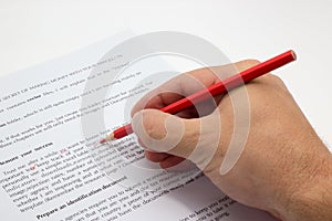 Hand doing proofreading on a faulty text with red pen