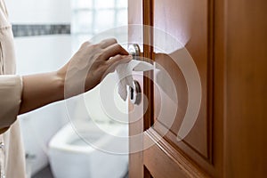 Hand with door handle,girl open the bathroom door,woman using tissue paper to touch the door knob instead of hands to prevent