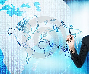 A hand is drawing the digital business world. The world map is drawn over the digital globe.